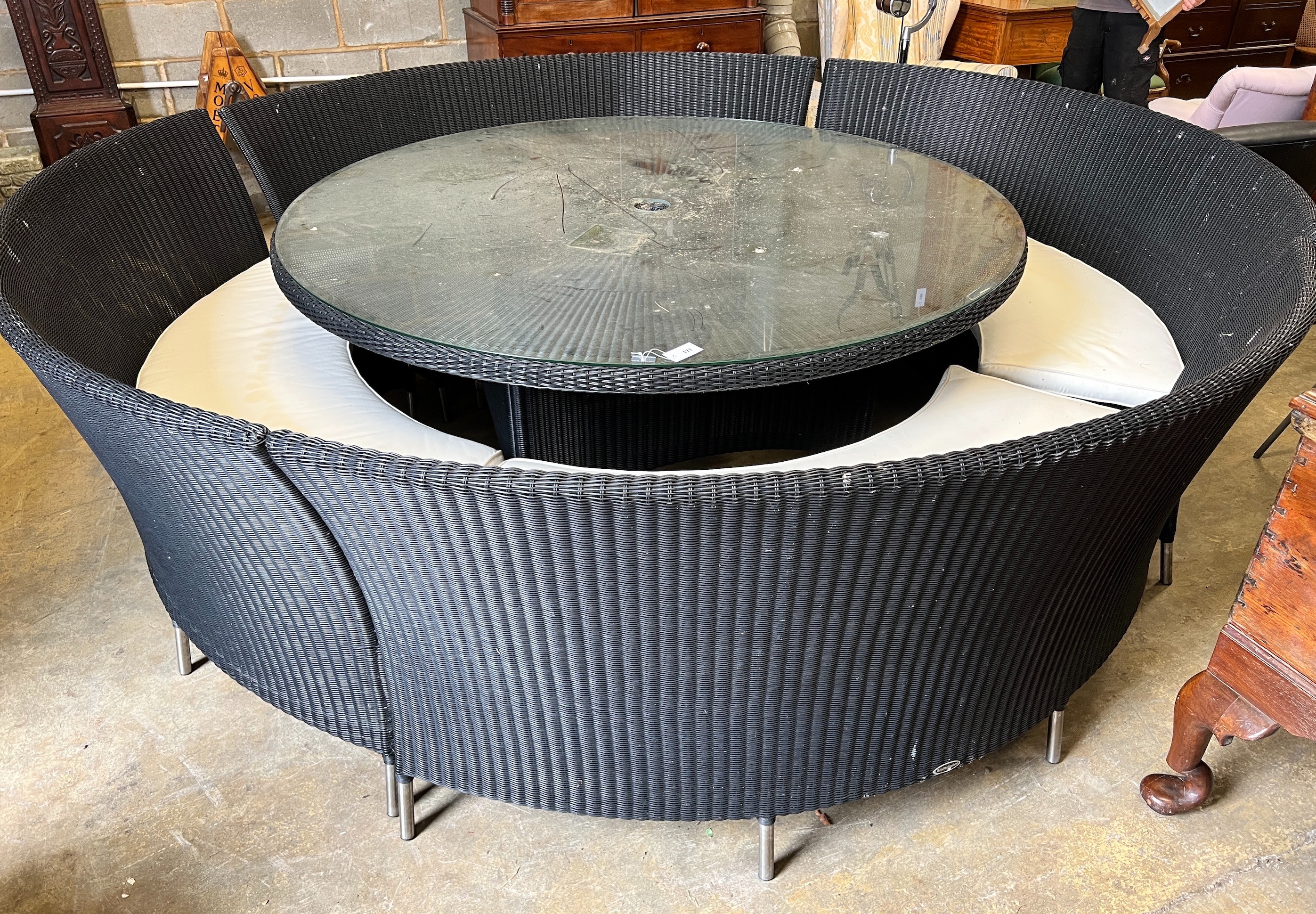 A large Westminster black all weather rattan circular topped garden table, diameter 180cm, height 74cm, together with four curved back seats and cushions